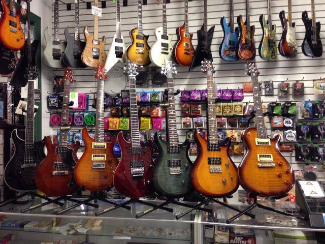 Electric guitars hanging on the wall at Route 1 Guitars in Milford