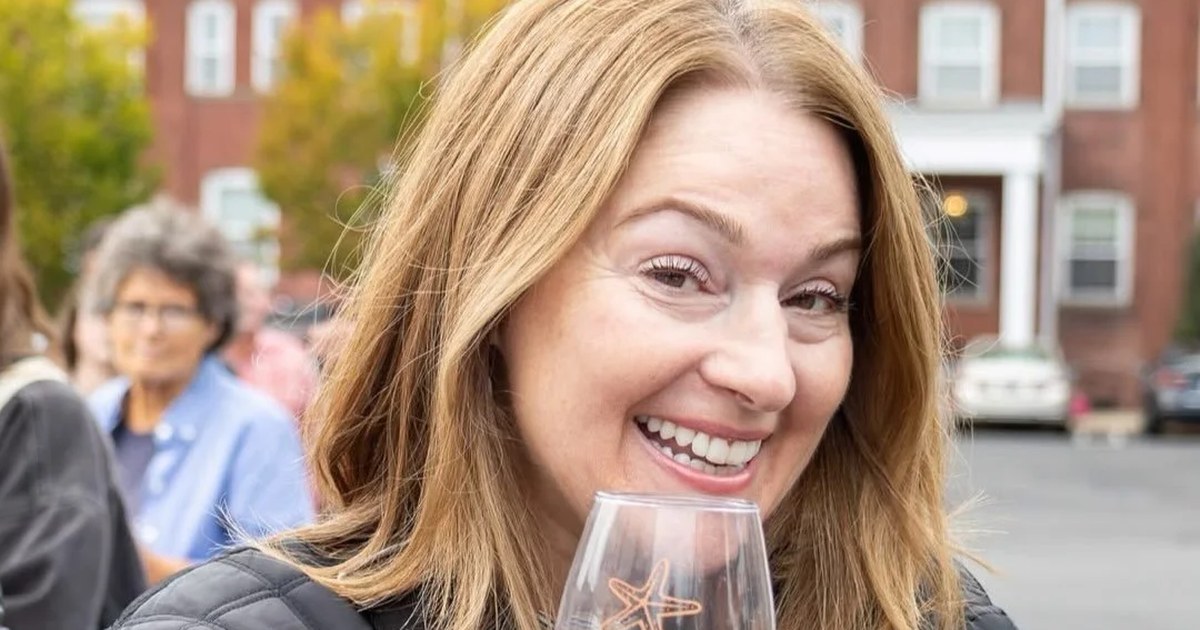 A guest holding a Downtown Milford Wine Trail glass